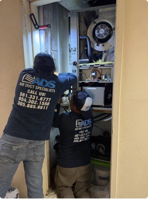 Air Duct Specialists LLC technicians diagnosing an air handler during an AC repair call in South Florida