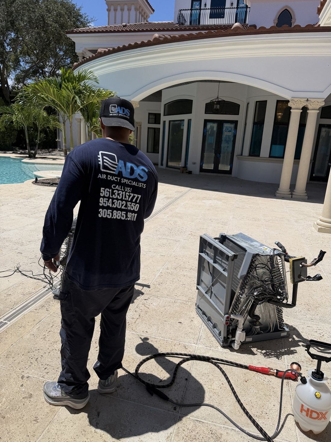 Evaporator coils from both air handlers removed for cleaning beside the pool deck of a Boca Raton estate home