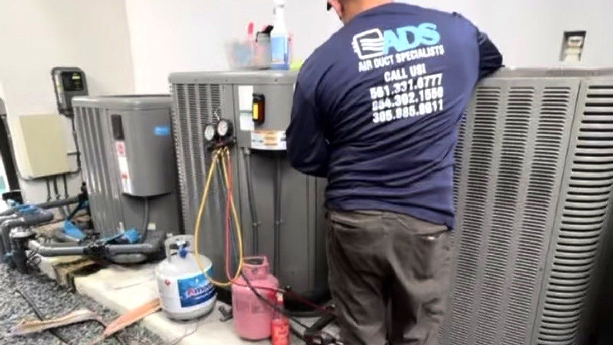 Air Duct Specialists LLC technician charging refrigerant during an AC repair in Coral Gables, Miami FL