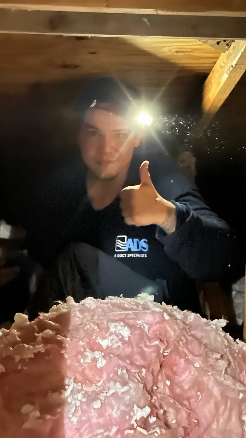 Albert of Air Duct Specialists LLC giving a thumbs up in a South Florida attic