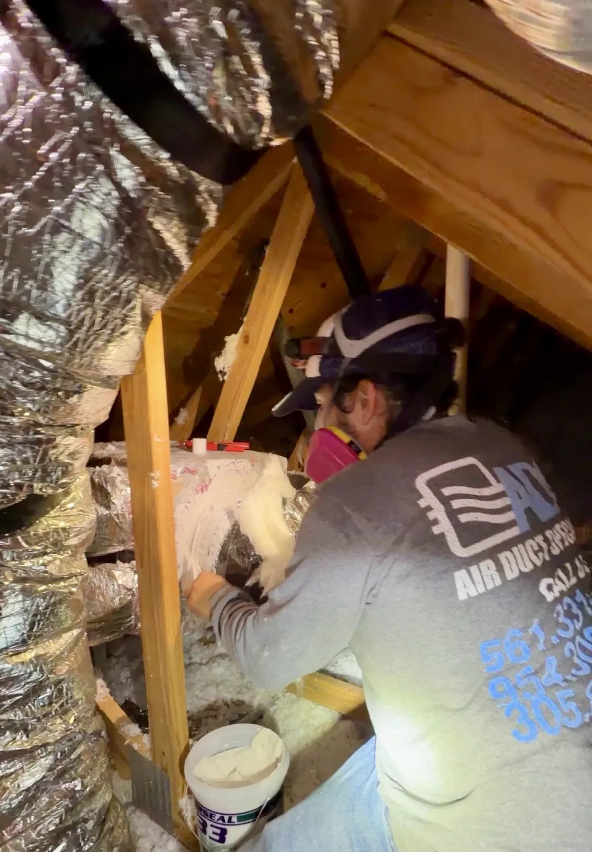 Technician applying mastic sealant to a new duct connection — Air Duct Specialists LLC