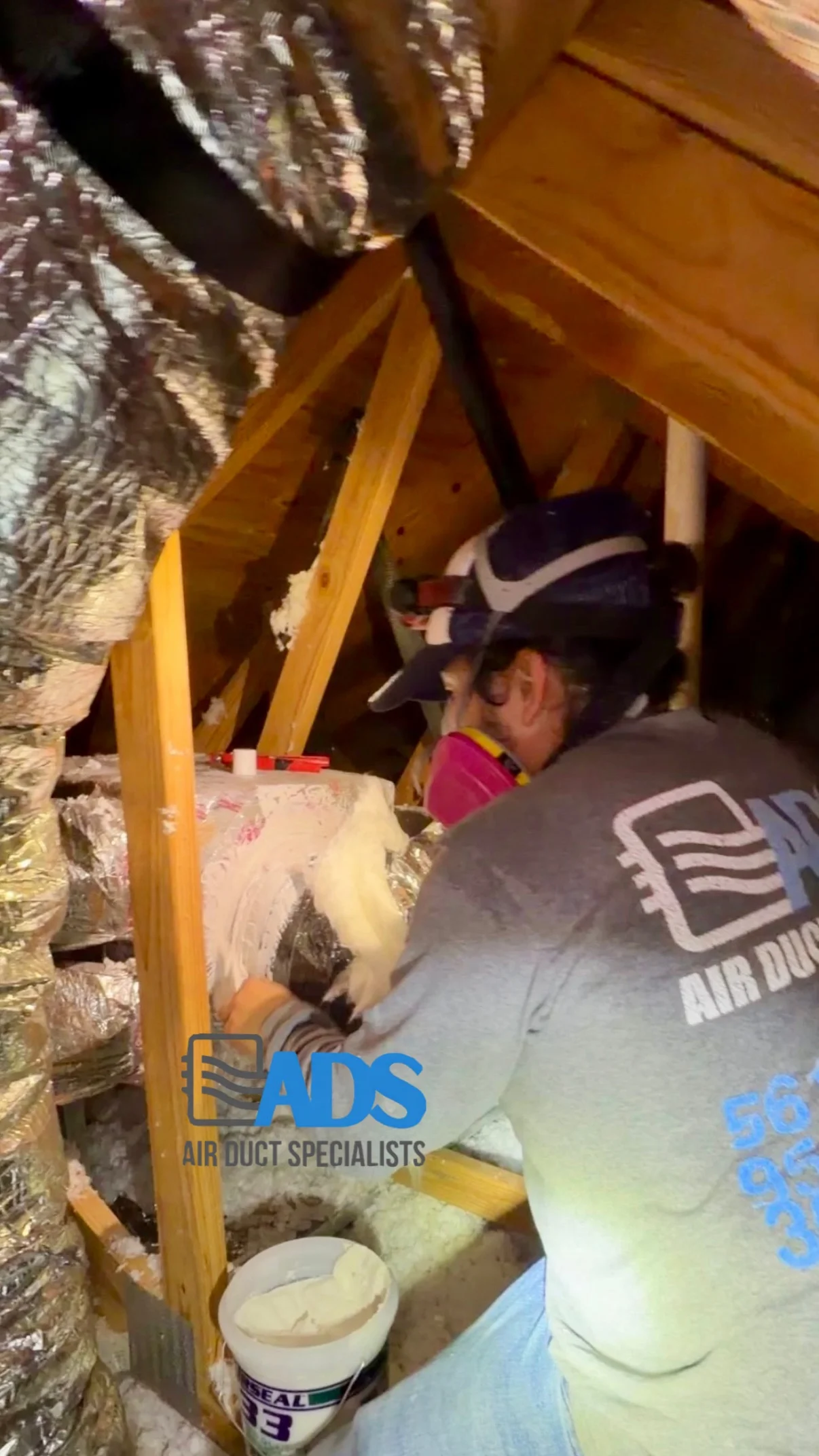 Air Duct Specialists technician sealing a duct connection in an attic — Air Duct Specialists LLC