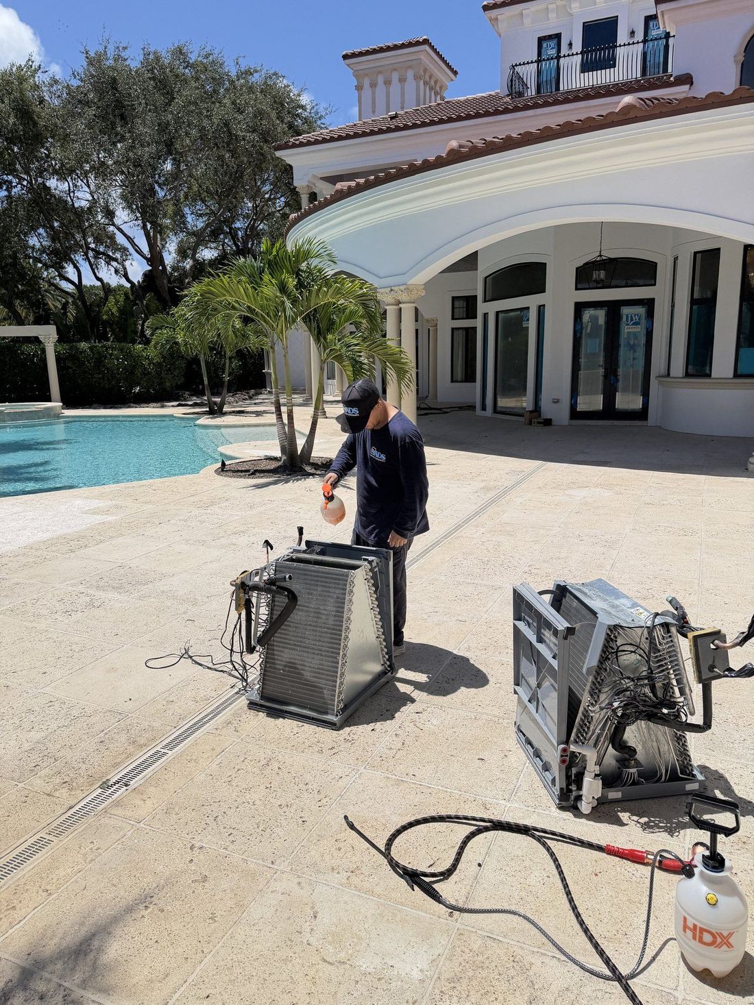 Evaporator coils removed from air handlers and being cleaned outside a Boca Raton estate home
