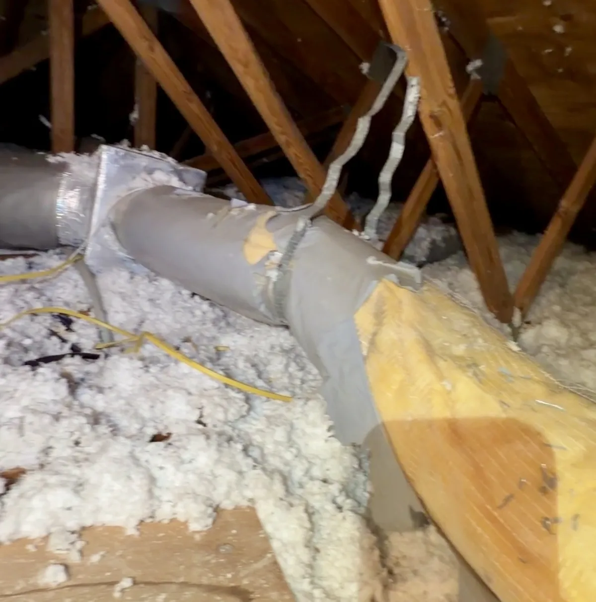 Ripped air duct with exposed insulation in a Plantation attic — Air Duct Specialists LLC