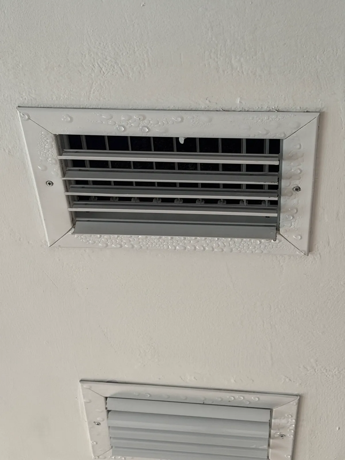 Condensation droplets beading on an air vent register — a sign of failing duct insulation — Air Duct Specialists LLC