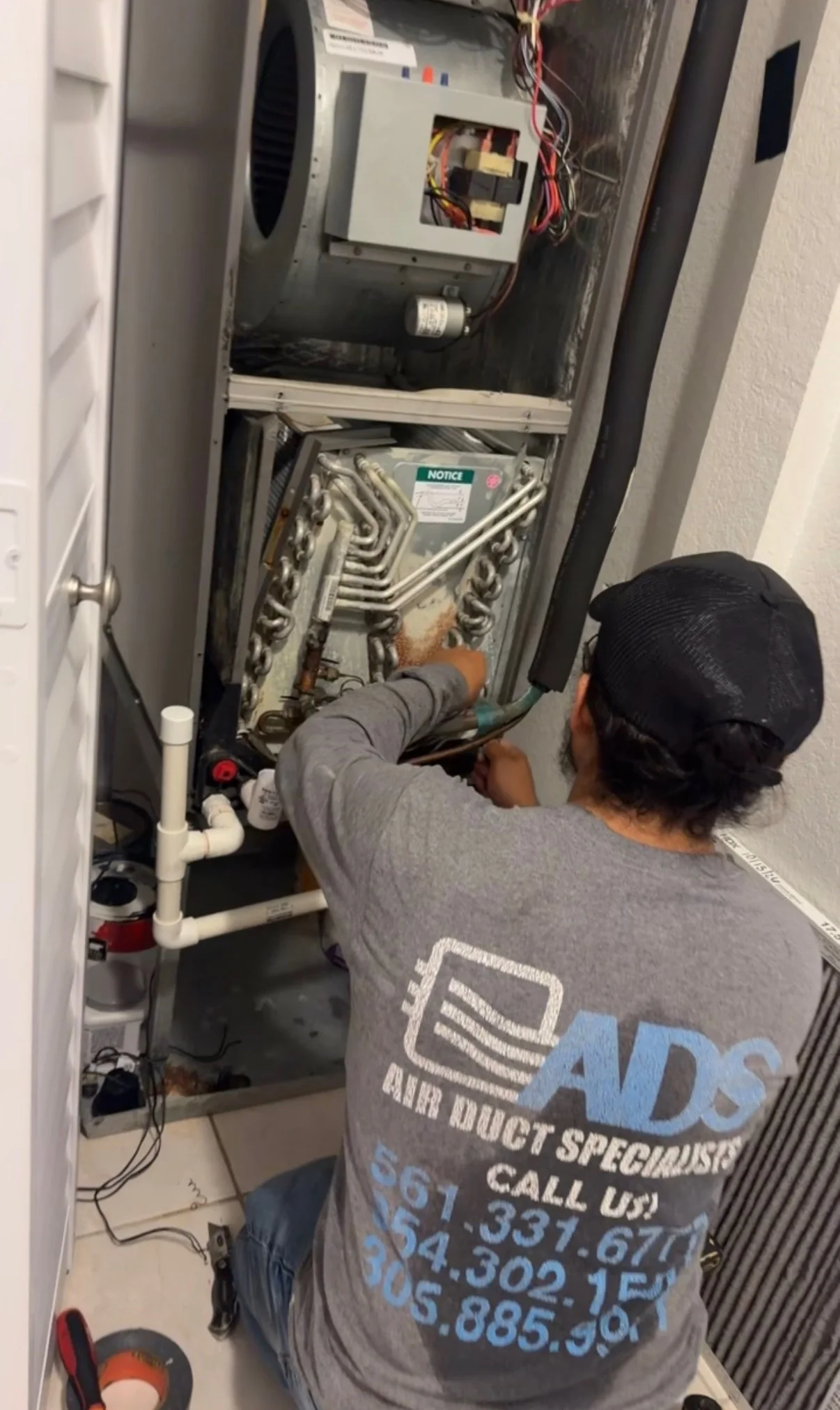 Technician servicing an open air handler with the coil exposed — Air Duct Specialists LLC