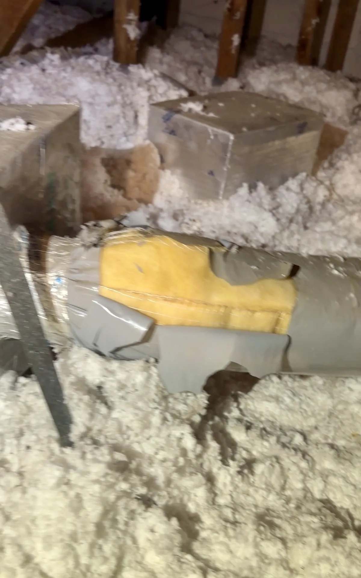 Close-up of a torn air duct with exposed insulation in a Plantation attic — Air Duct Specialists LLC